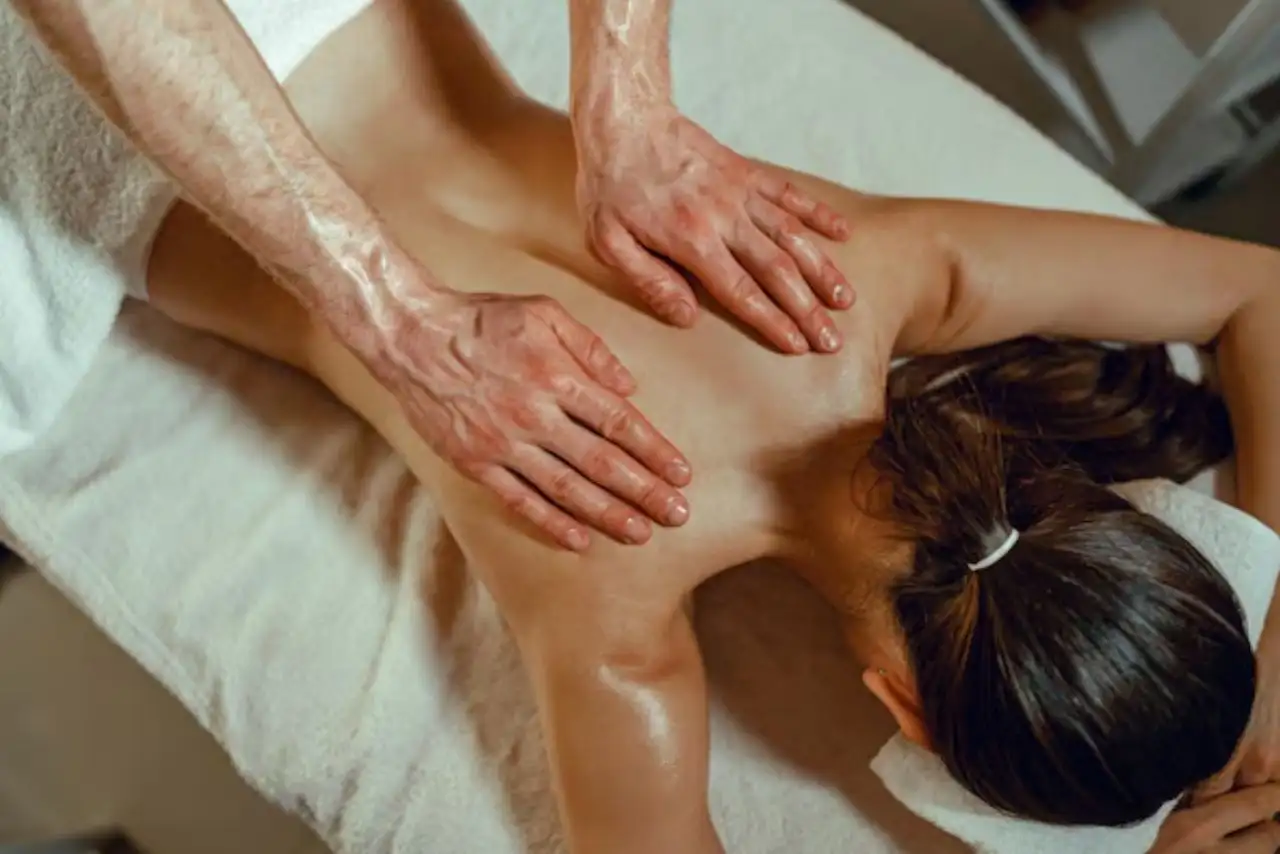 Woman getting back massage from male therapist.